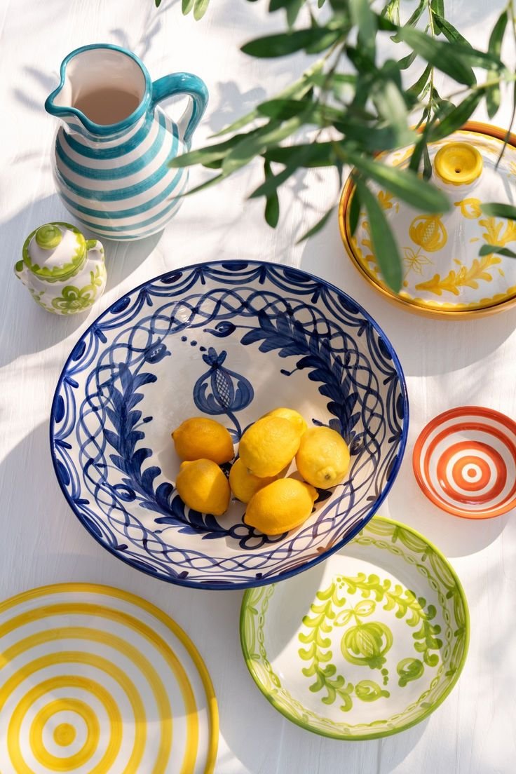 Hand-painted Sicilian ceramics and fresh lemons on a sunlit table.