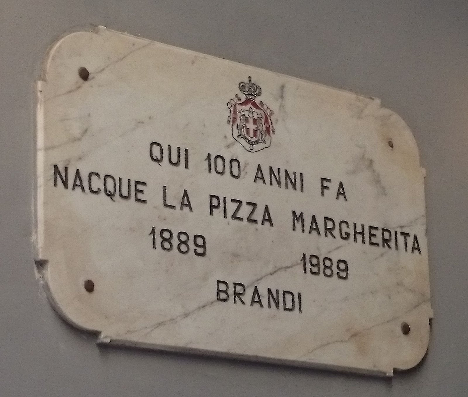 The marble plaque at Pizzeria Brandi in Naples marking the birth of the pizza Margherita in 1889.