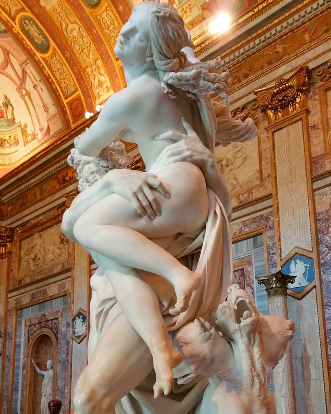 Bernini’s Rape of Proserpina in marble beneath the frescoed vaults of the Galleria Borghese.
