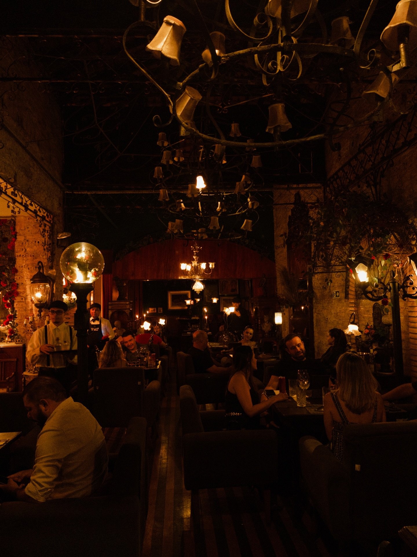 A Venetian room at night, lamps lit, tables full