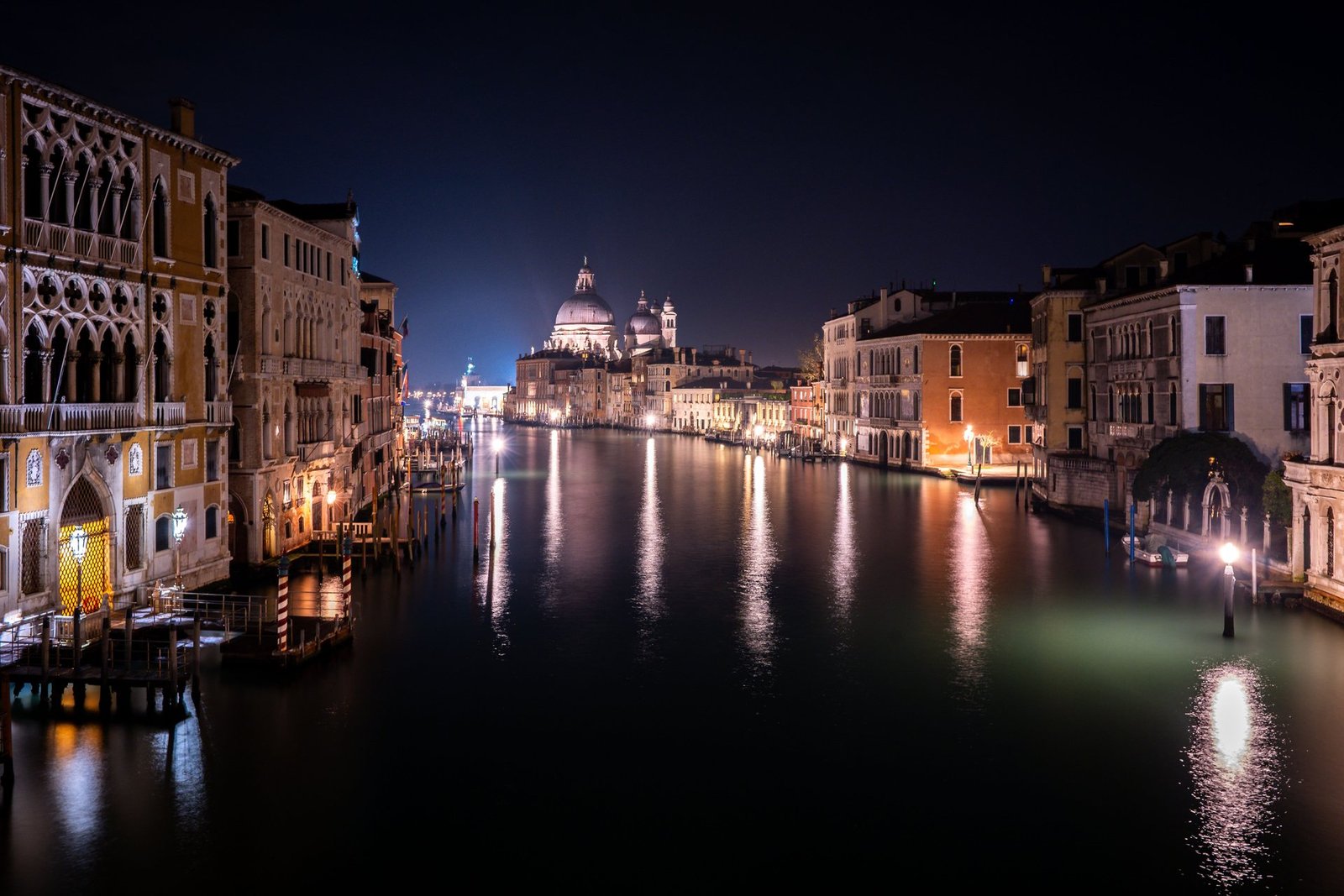 Venice canal illuminated in blue tones at night, Italy